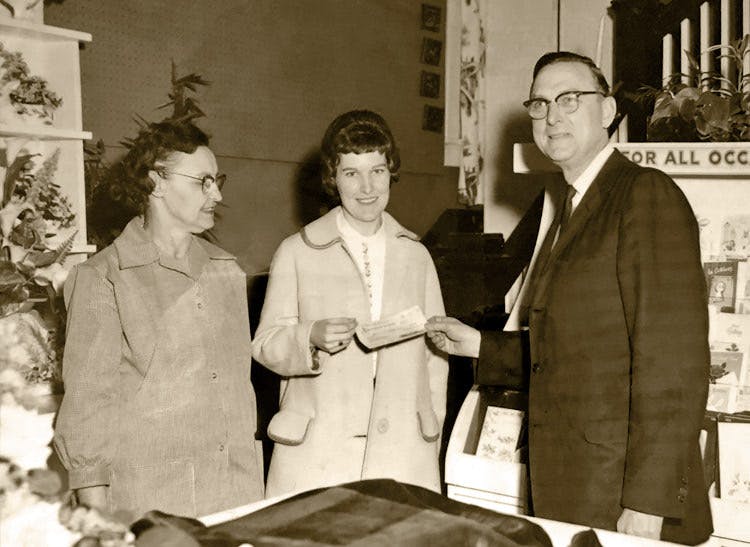This black-and-white photo depicts management interacting with customers in our showroom